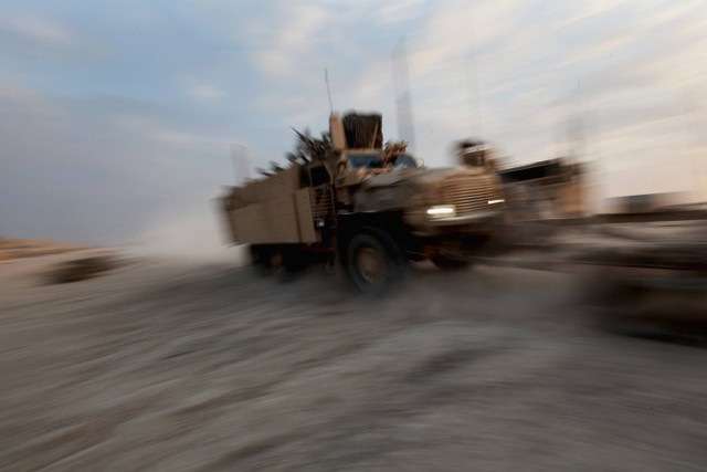 Kendaraan Perlindungan Penyergapan Tahan Ranjau (MRAP) melewati Kamp Adder yang hampir sepi, sekarang dikenal sebagai Pangkalan Imam Ali, Irak, pada 16 Desember 2011. Foto: MARIO TAMA / POOL / AFP