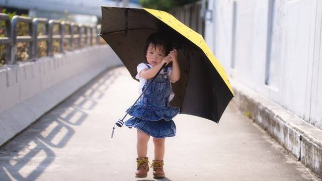 Ilustrasi anak balita menggunakan payung di cuaca panas. Foto: Shutter Stock