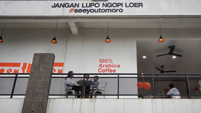 Tagline berbahasa Palembang yang tertulis di bagian gedung lantai dua Tomoro kopi yang baru membuka cabangnya di area PTC mal, Sabtu (27/1) Foto: ary priyanto/urban id