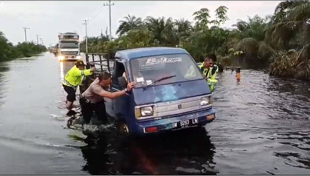 Kendaraan terjebak banjir di Jalan Lintas Timur Sumatera, khususnya di Kilometer 83 Kecamatan Pangkalan Kerinci. Foto: Dok. Istimewa