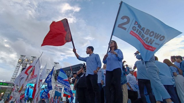 Momen cawapres nomor urut 02, Gibran Rakabuming Raka dan istrinya, Selvi Ananda mengibarkan bendera relawan berwarna merah dan relawan Prabowo-Gibran dalam acara Kirab Kebangsaan Prabowo-Gibran di Simpang Lima, Semarang, Jawa Tengah, Minggu (28/1).  Foto: Zamachsyari/kumparan