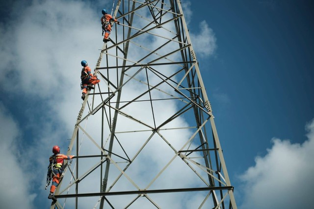 Ilustrasi petugas PLN tengah memastikan kelayakan Saluran Udara Tegangan Tinggi (SUTT) sebelum infrastruktur tersebut dioperasikan. Foto: PLN