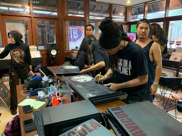 Gitaris Navicula Dadang Pranoto membubuhkan tanda-tangan di vinyl yang terjual - IST