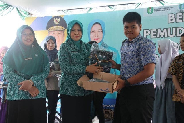 Kadisporapar Kalbar, Windy Prihastari serahkan baju olah raga dan sepatu kepada pemuda di PLBN Aruk, Sambas. Foto: Dok. Adpim Pemprov Kalbar