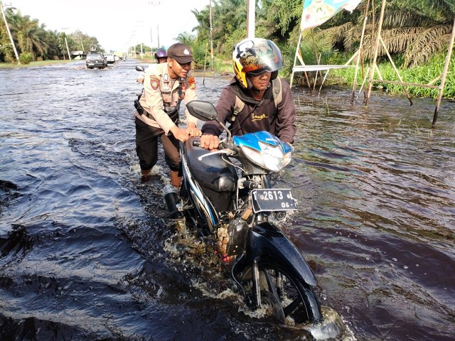 Polisi membantu warga Pelalawan, Riau, yang terjebak banjir. Foto: Dok. Istimewa