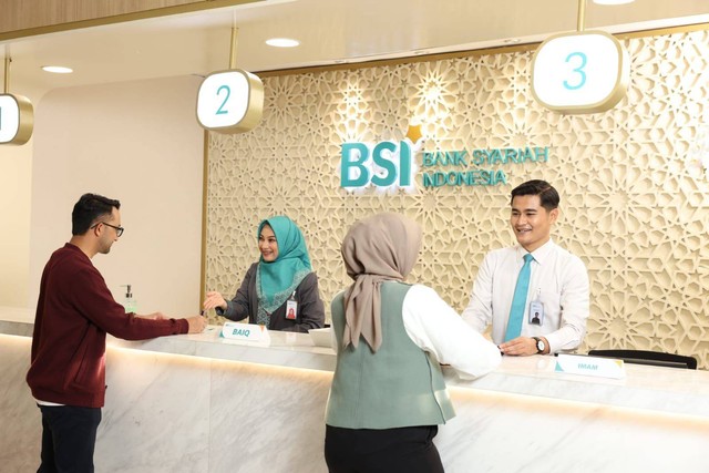 Petugas teller BSI sedang melayanani transaksi nasabah di BSI Kantor Cabang Jakarta The Tower. BSI menyediakan layanan operasional akhir pekan (weekend banking) di 459 kantor cabang BSI di seluruh Indonesia. Foto: Dok. BSI