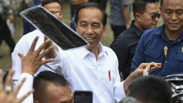 Presiden Joko Widodo (kanan) membagikan kaus kepada warga saat bersilaturahmi dengan nasabah program Mekaar di Bandung, Jawa Barat, Sabtu (3/2/2024). Foto: ANTARA FOTO/Hafidz Mubarak A