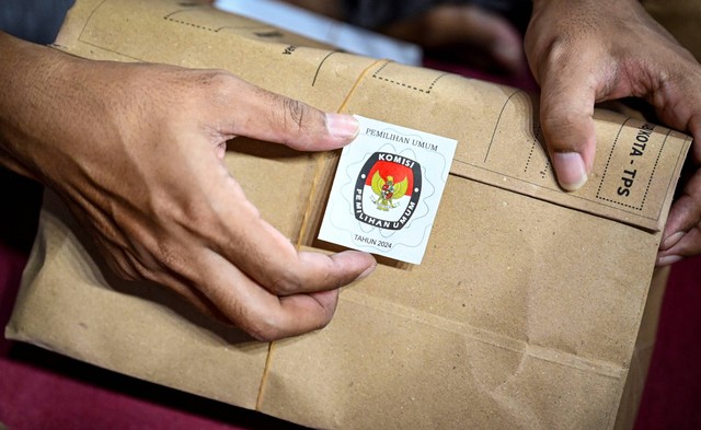 Petugas Kelompok Panitia Pemungutan Suara (KPPS) menyegel amplop berisi surat suara Pemilu 2024 di gudang logistik KPU Jakarta Pusat, GOR Cempaka Putih, Jakarta, Senin (5/2/2024). Foto: Erlangga Bregas Prakoso/ANTARA FOTO