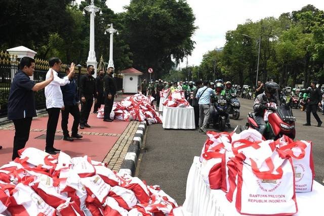 Presiden Joko Widodo menyaksikan penyerahan bantuan paket sembako bagi para pengemudi ojek daring atau ojol di sekitar Kompleks Istana Kepresidenan, Jakarta, pada Kamis, 13 April 2023. Foto: Kris/Biro Pers Sekretariat Presiden