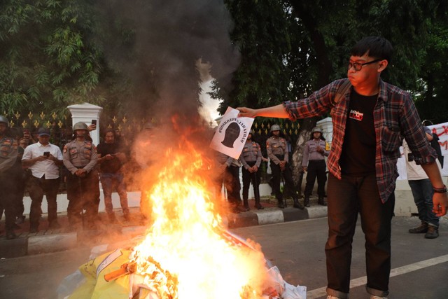 Mahasiswa yang unjuk rasa membakar spanduk di Istana Merdeka, Jakarta Pusat, Rabu (7/2/2024). Foto: Jamal Ramadhan/kumparan