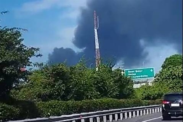 Asap pekat membubung terlihat dari jalan tol jelang Bandara Soetta, akibat kebakaran pabrik furnitur di Kalideres Kamis (8/2/2024). Foto: Dicky Adam Sidiq/kumparan