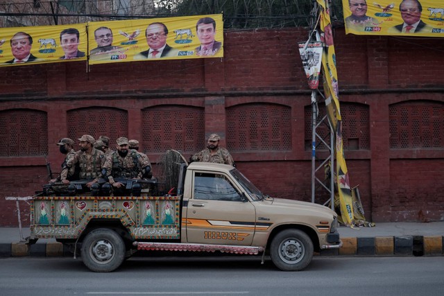 Personel tentara duduk di dalam kendaraan dekat tempat pemungutan suara pada hari pemilihan umum, di Lahore, Pakistan, Kamis (8/2/2024). Foto: Navesh Chitrakar/REUTERS