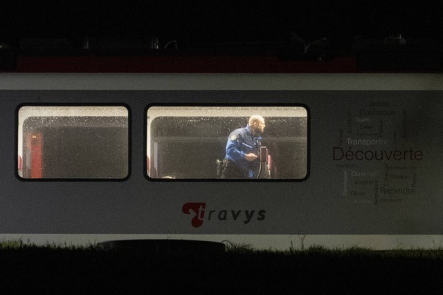 Anggota polisi memeriksa bagian dalam kereta, tempat penumpang yang melakukan perjalanan dari Yverdon ke Sainte-Croix sebelumnya disandera, di Essert-Sous-Champvent, Swiss barat pada 9 Februari 2024. Foto: Fabrice Coffrini/AFP