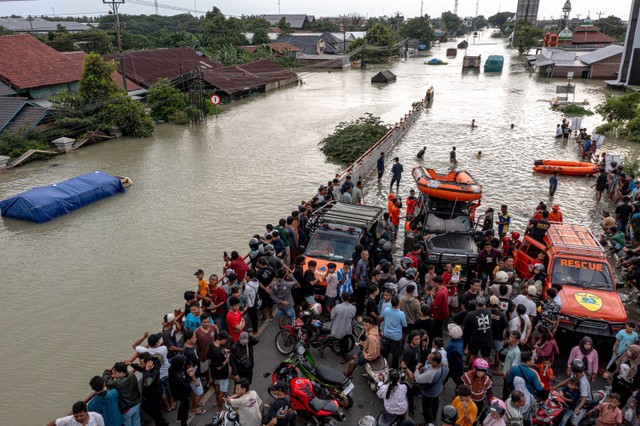 Foto udara warga memadati sekitar posko darurat banjir Demak untuk menyaksikan banjir dari Jembatan Tanggulangin perbatasan Demak-Kudus di Karanganyar, Kabupaten Demak, Jawa Tengah, Jumat (9/2/2024). Foto: Aji Styawan/Antara Foto