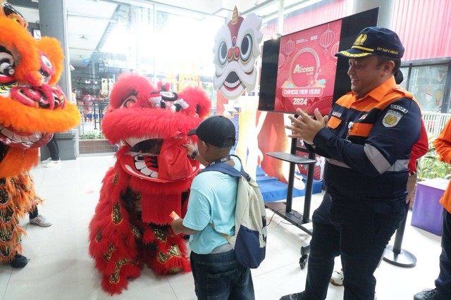 Aksi Barongsai Bagi-bagi Kue Keranjang untuk Penumpang KA di Stasiun Surabaya