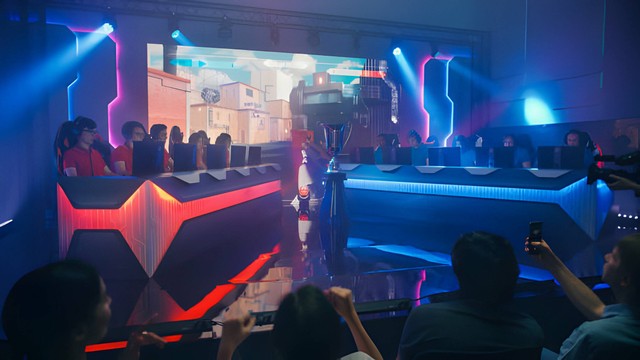 Dua Tim E-sport Gamer Pro Bermain di Video Game FPS Shooter di Arena Kejuaraan. Sumber : https://www.istockphoto.com/