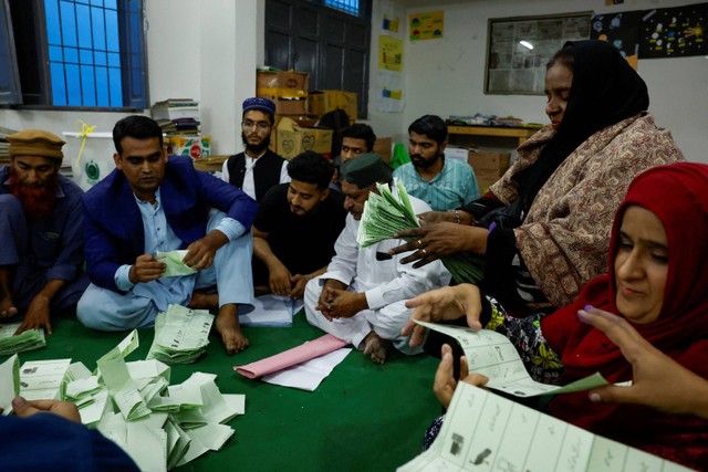 Petugas pemungutan suara menghitung surat suara selama pemilihan umum di Karachi, Pakistan 8 Februari 2024. Foto: Akhtar Soomro/Reuters