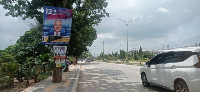 Spanduk caleg yang masih berada di pohon di saat masa tenang, Foto : Abdul Toriq/ Urban Id