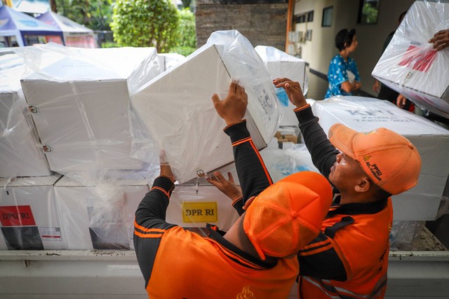 Petugas Penanganan Prasarana dan Sarana Umum (PPSU) tengah mengangkat kotak suara untuk didistribusikan ke Kecamatan Cempaka Putih , Jakarta Timur, Selasa (13/2/2024).  Foto: Iqbal Firdaus/kumparan