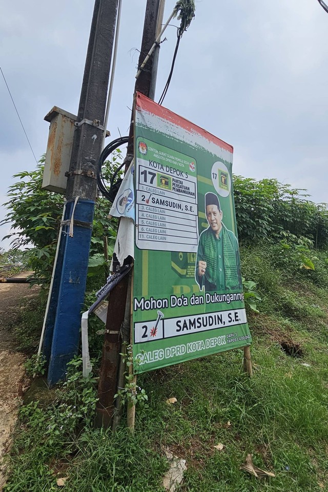 Alat peraga kampanye masih terpasang di kawasan Kecamatan Tapos, Depok, Selasa (13/2/2024). Foto: kumparan