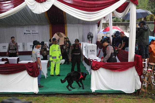 Polisi dengan anjing pelacak K9 melakukan pemeriksaan di TPS 033 Bojong Koneng, tempat capres nomor urut 02 Prabowo Subianto memberikan suara Pemilu 2024 di Bogor, Rabu (14/2/2024). Foto: Jamal Ramadhan/kumparan