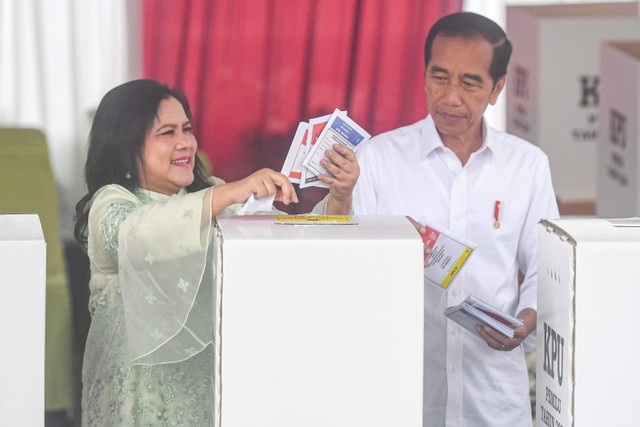 Presiden Joko Widodo (kanan) bersama Ibu Negara Iriana (kiri) memasukkan surat suara ke dalam kotak pada Pemilu 2024 di tempat pemungutan suara (TPS) 10 Kelurahan Gambir, kompleks Kantor Lembaga Administrasi Negara (LAN), Jakarta, Rabu (14/2/2024). Foto: Muhammad Adimaja/ANTARA FOTO