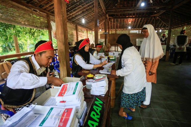 Petugas KPPS berkostum penari badui menyerahkan surat suara Pemilu 2024 kepada warga di TPS 102 di Maguwoharjo, Sleman, DI Yogyakarta, Rabu (14/2/2024).  Foto: Hendra Nurdiyansyah/ANTARA FOTO