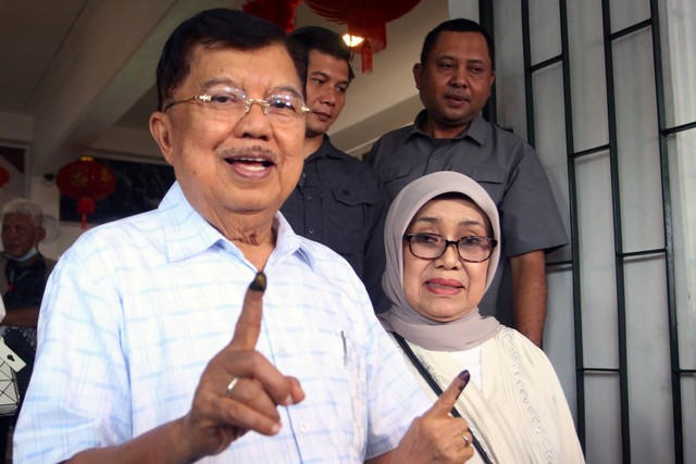 Mantan Wapres Muhammad Jusuf Kalla (kiri) bersama istri Mufidah Jusuf Kalla (kanan) menunjukkan jarinya yang sudah dicelup tinta usai menggunakan hak pilihnya pada Pemilu 2024 di TPS 03 Kelurahan Pulo, Kebayoran Baru, Jakarta, Rabu (14/2/2024). Foto: Muhammad Iqbal/ANTARA FOTO