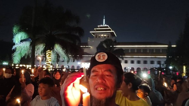 Pendukung Prabowo-Gibran nyalakan lilin dan sujud syukur atas hasil hitung cepat di Gedung Sate, Kota Bandung, pada Rabu (14/2/2024) malam. Foto: Rachmadi Rasyad/kumparan