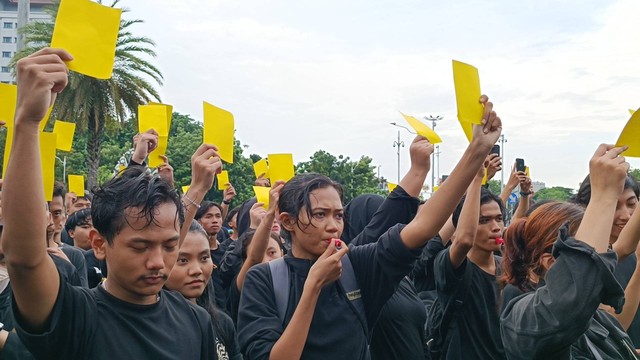 Aksi Kamisan turut menampilkan teatrikal dengan massa aksi memegang kartu kuning sambil meniup peluit menghadap ke Istana Presiden, Jalan Medan Merdeka Utara, Jakarta, Kamis (15/2/204). Foto: Fadhil Pramudya/kumparan