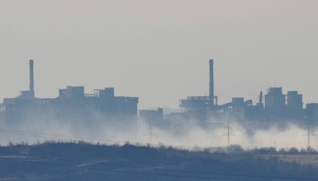 Asap mengepul di dekat Pabrik Kokas dan Kimia Avdiivka di kota Avdiivka selama konflik Rusia-Ukraina, seperti yang terlihat dari Yasynuvata (Yasinovataya) di wilayah Donetsk, Ukraina (15/2). Foto: Serhii Nuzhnenko/REUTERS