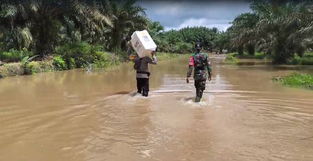 Petugas mengawal pengembalian logistik di Kecamatan Belitang Hilir, Kabupaten Sekadau, menerjang banjir. Foto: Dok. Polres Sekadau