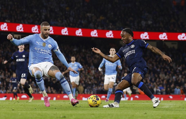 Raheem Sterling menggocek Kyle Walker sebelum mencetak gol saat laga Man City vs Chelsea dalam pekan ke-25 Liga Inggris 2023/24 di Stadion Etihad pada Minggu (18/2) dini hari WIB. Foto: Action Images via Reuters/Jason Cairnduff