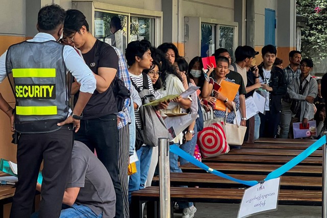 Orang-orang mengantre untuk mendapatkan visa di depan kedutaan Thailand di Yangon, Myanmar, Jumat (16/2/2024). Foto: STR/AFP