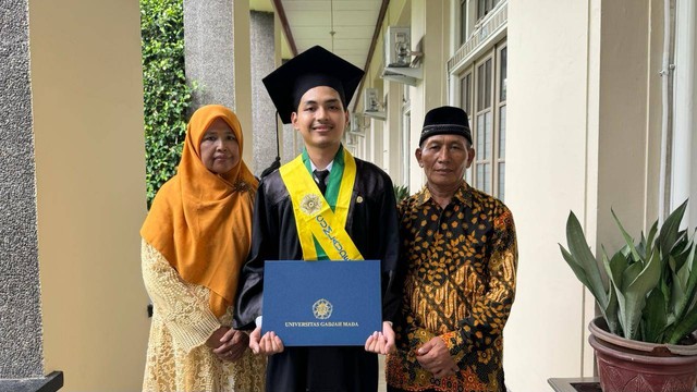 Muhammad Ikhsanudin Alamin, salah satu wisudawan terbaik UGM, berfoto bersama kedua orang tuanya, Rabu (21/2). Foto: Arif UT/Pandangan Jogja