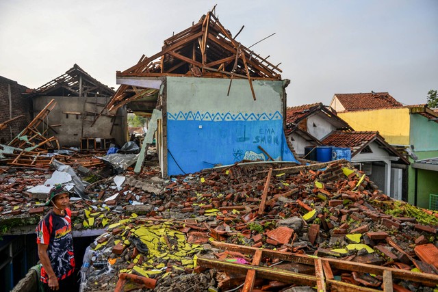 Warga berdiri di antara puing rumah yang hancur akibat angin puting beliung di Desa Sukadana, Kabupaten Sumedang, Jawa Barat, Kamis (22/2/2024). Foto: Raisan Al Farisi/ANTARA FOTO