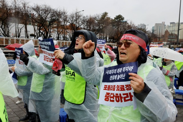Para dokter dan pekerja medis mengambil bagian dalam protes terhadap rencana penerimaan lebih banyak siswa ke sekolah kedokteran, di depan Kantor Kepresidenan di Seoul, Korea Selatan, Rabu (21/2/2024). Foto: Kim Soo-Hyeon/REUTERS