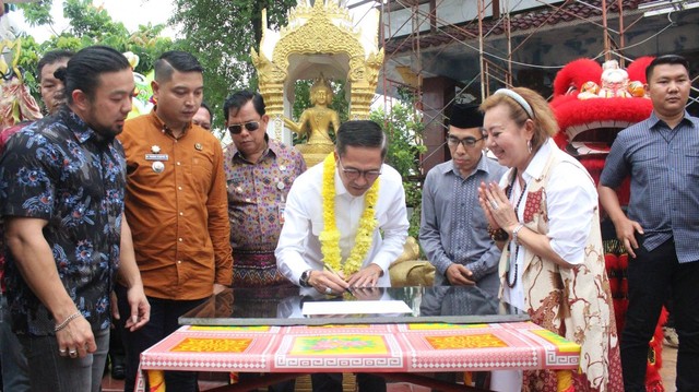 Pj Wali Kota Palembang, Ratu Dewa, saat menandatangani prasasti pembangunan musala di Vihara Sembilan Bidadari. (ist)