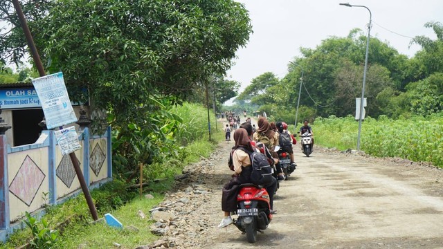 Para siswa di SMP Negeri 2 Prambanan, Sleman, saat pulang sekolah dan melewati jalan yang rusak akibat tambang ilegal. Foto: Widi RH Pradana/Pandangan Jogja