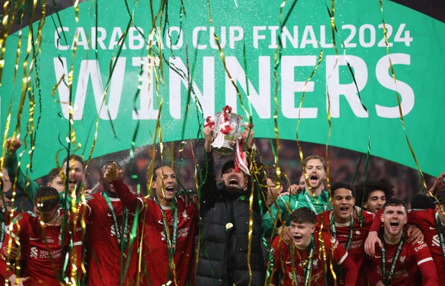 Manajer Liverpool Juergen Klopp dan Virgil van Dijk merayakan kemenangan Piala Carabao dengan trofi dan rekan satu tim. Foto: REUTERS/Hannah Mckay