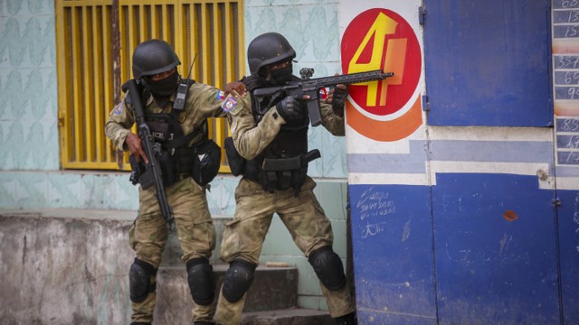 Polisi berlindung selama operasi anti-geng di lingkungan Portail di Port-au-Prince, Haiti, Kamis, 29 Februari 2024. Foto: AP/Odelyn Joseph