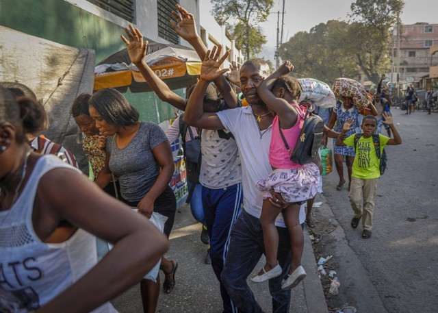 Warga meninggalkan rumah mereka saat terjadi bentrokan antara polisi dan anggota geng di lingkungan Portail di Port-au-Prince, Haiti, Kamis, 29 Februari 2024. Foto: AP/Odelyn Joseph