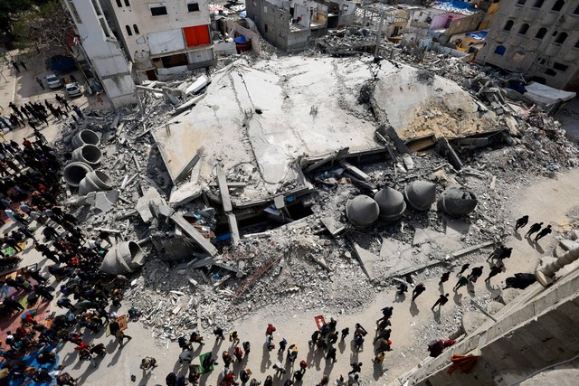 Warga Palestina berkumpul untuk salat Jumat di dekat reruntuhan masjid yang hancur akibat serangan Israel, di tengah konflik yang sedang berlangsung antara Israel dan Hamas, di Rafah di selatan Jalur Gaza, Jumat (1/3/2024). Foto: Mohammed Salem/REUTERS
