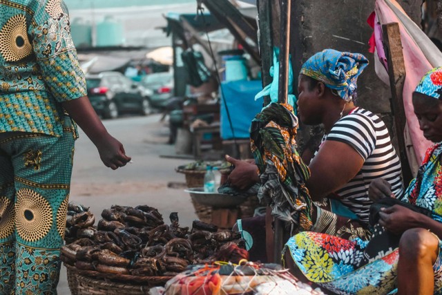 Photo by O'Graphy  Inc: https://www.pexels.com/photo/woman-sitting-and-working-at-market-on-street-15927123/