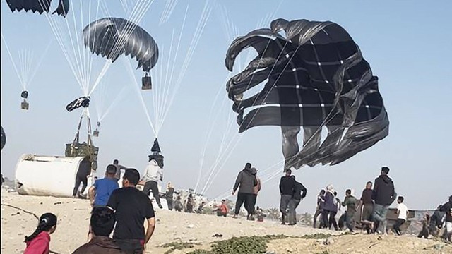Warga Palestina berlari menuju parasut yang membawa paket makanan, yang dijatuhkan dari pesawat AS di pantai Jalur Gaza pada tanggal 2 Maret 2024. Foto: AFP