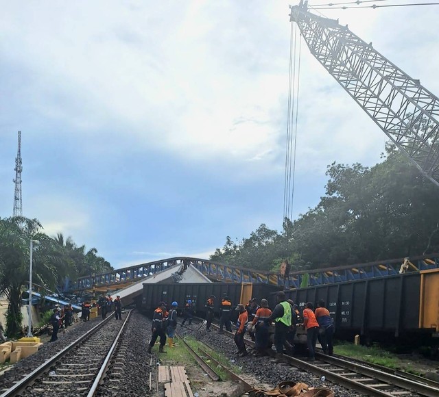 Petugas masih melakukan evakuasi rangkaian kereta yang tertimpa girder flyover di Muara Enim. (foto: dok. Urban Id)