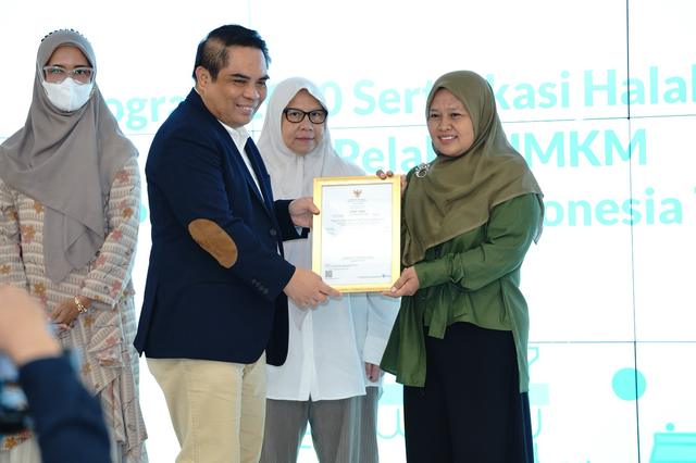 Direktur Sales & Distribution BSI, Anton Sukarna membagikan sertifikat halal kepada pelaku UMKM lewat program Selasar. Foto: Dok. BSI