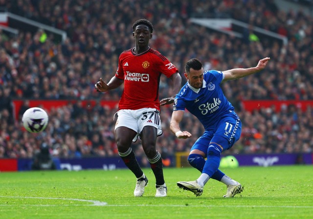 Kobbie Mainoo berdiri dekat Jack Harrison yang melepas sepakan saat laga Manchester United vs Everton dalam pekan ke-28 Liga Inggris 2023/24 di Stadion Old Trafford pada Sabtu (9/3) malam WIB. Foto: REUTERS/Molly Darlington