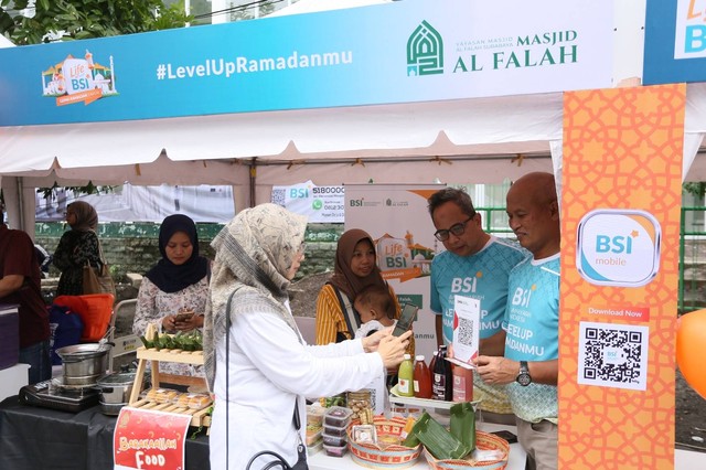 Direktur Retail Banking BSI Ngatari (tengah) menyapa pengunjung masjid dan menunjukkan QRIS untuk pembayaran umkm di area masjid. Selama ramadhan, BSI mendorong digitalisasi umkm melalui optimalisasi layanan masjid untuk meningkatkan ekosistem halal. Foto: dok. BSI 