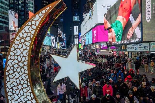 Warga muslim melaksanakan salat tarawih di Times Square, New York City, Amerika Serikat, Minggu (10/3/2024). Foto: Adam Gray / AFP